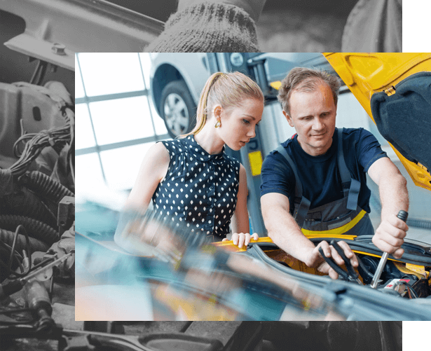 Mechanic and woman working on a car engine