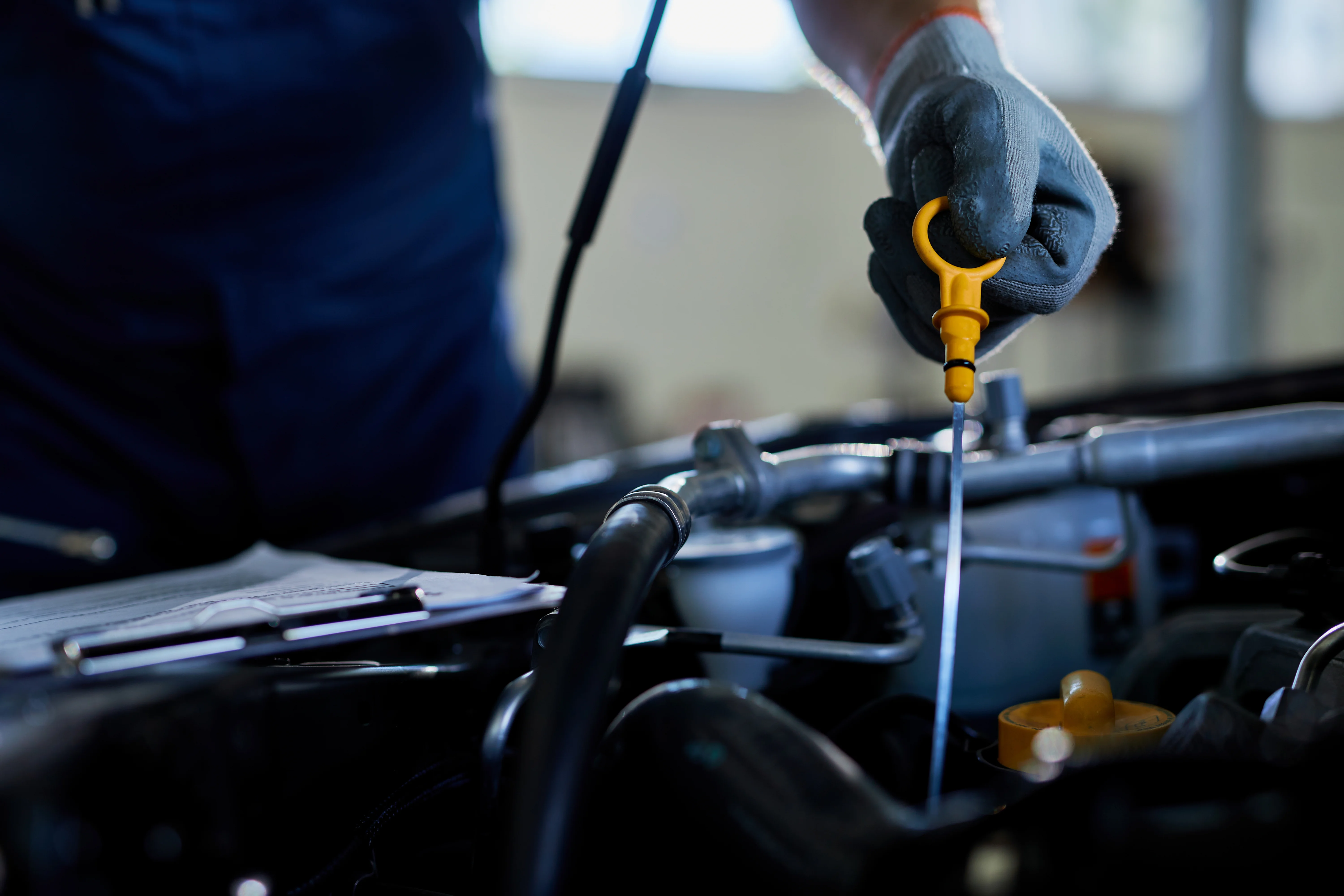 Mechanic checking oil level in car engine